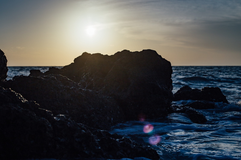 lens flare, tranquility, waves, rock formation, water, beach, ocean, no people, tranquil scene, foam, solid, black, scenics - nature, horizon, rocks, beauty in nature