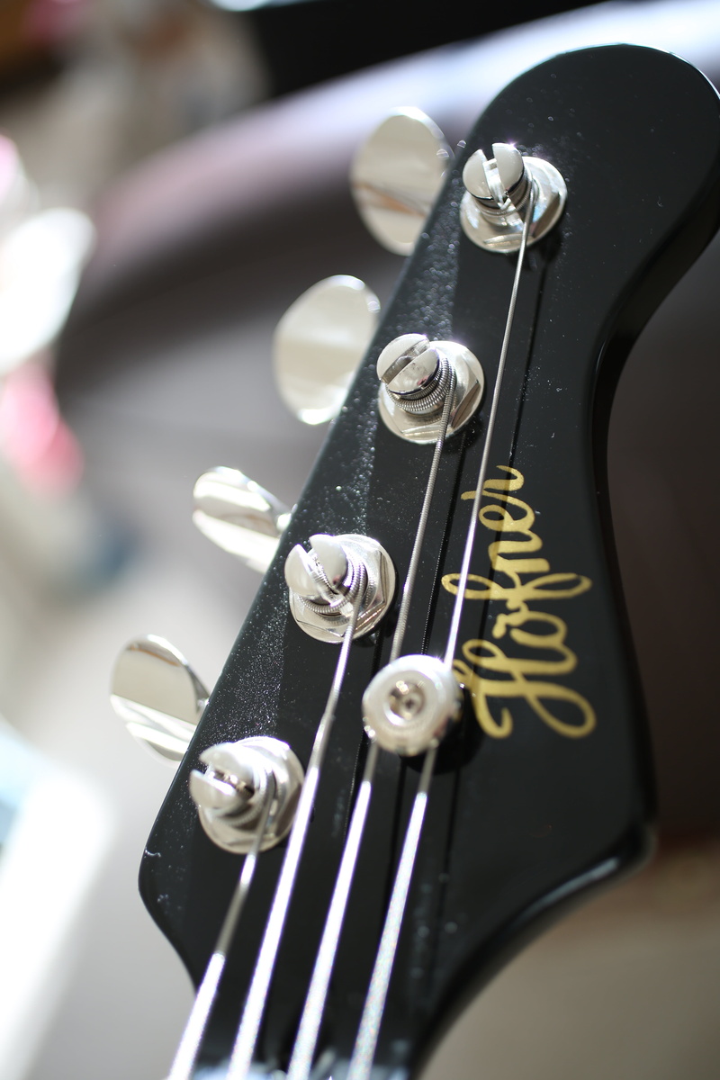 guitar head, still life, guitar, hanging, text, metal, 5K, creativity, string instrument, arts culture and entertainment, high angle view, bass, no people