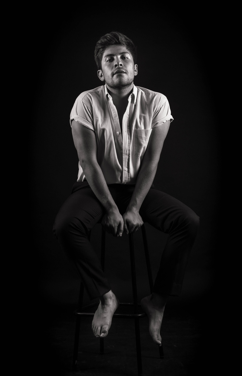 finger, arm, looking at camera, studio shot, indoors, jaw, black background, casual clothing, sitting, 5K, one person, cut out, seat, full length, photo