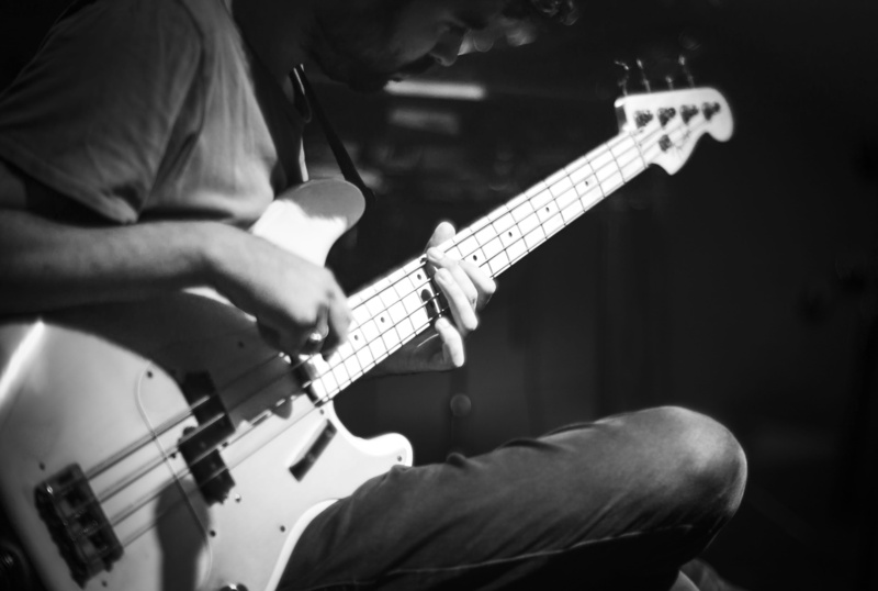 player, electric guitar, performance, string instrument, plucking an instrument, black and white, arts culture and entertainment, playing, bass guitar
