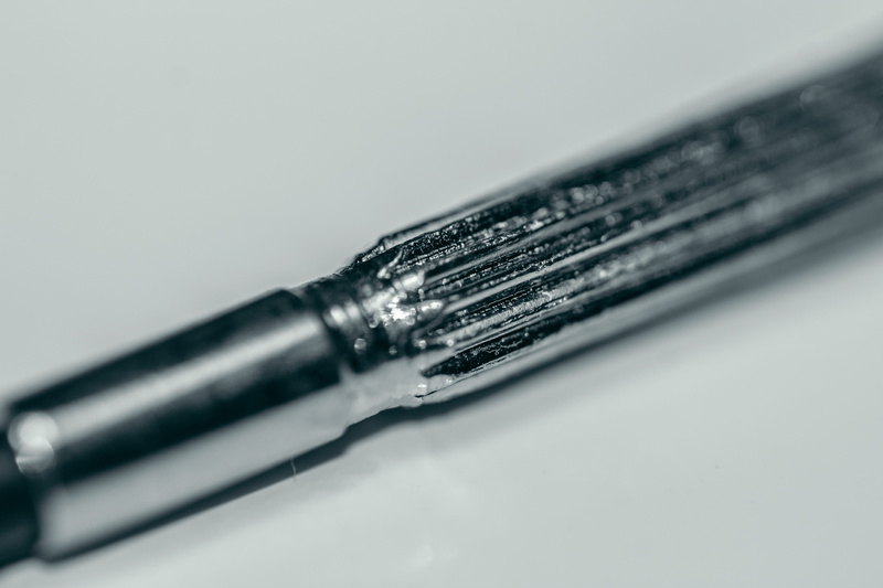 studio shot, blade, indoors, writing instrument, pen, injection, close-up, screwdriver, ink, white background, calligraphy, silver colored, still life