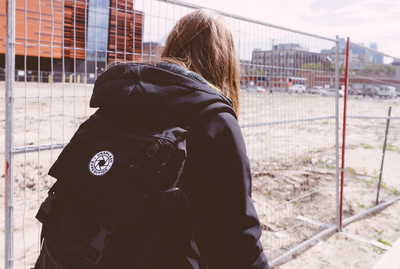 lot, hood - clothing, day, urban, leisure activity, 5K, one person, rear view, casual clothing, downtown, woman, exploration, standing, person, adult