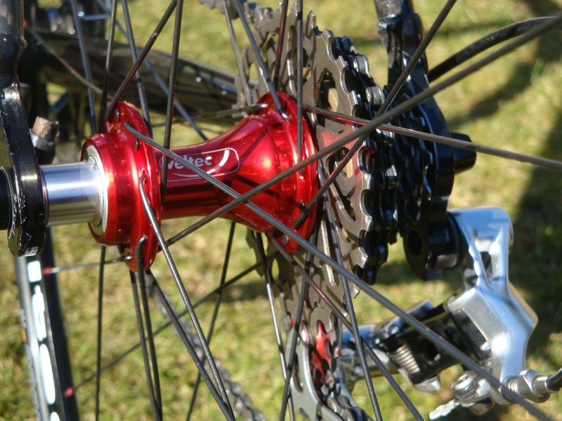 2K, barrier, land, field, machinery, mode of transportation, sunlight, land vehicle, bicycle, outdoors, day, wheel, spoke, red, grass, road bike, boundary