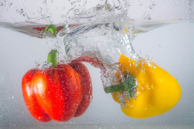 immersion, spill over, food, purity, two, wellbeing, bell, movement, studio shot, fruit, red, motion, water, close-up, yellow, wet, peppers, food and drink