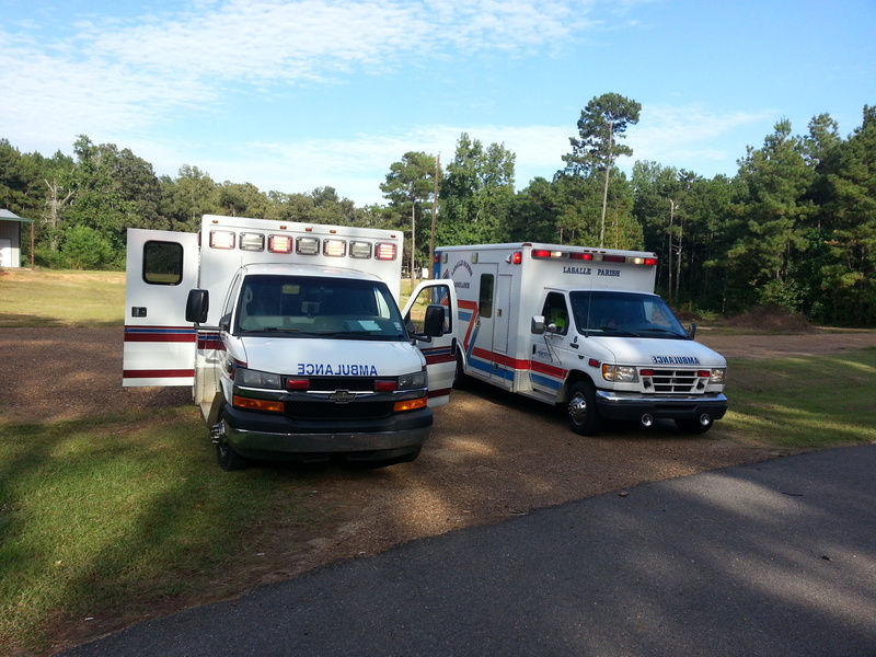 city, near, emergency vehicle, mode of transportation, 2K, street, land vehicle, medical, green, daytime, white, outdoors, ambulances, trees, rescue, transportation