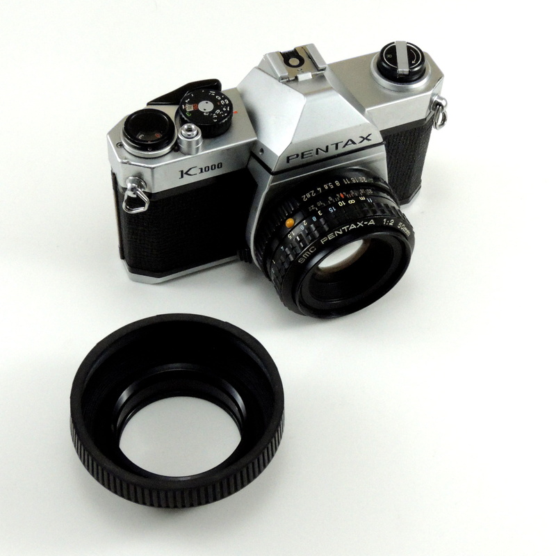 lens - eye, 50 mm, film reel, pentax, home video camera, lens, slr camera, high angle view, studio shot, k1000, indoors, 2K, no people, retro styled, former