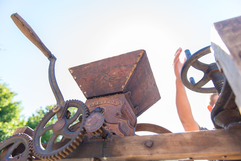 sunlight, one man only, outdoors, land vehicle, antique, machine part, machinery, nature, only men, holding, sculpture, industry, day, 5K, press, harvest