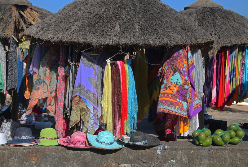 hats, sarongs, market, flea market, merchandise, roof, multi colored, built structure, thatched roofs, large group of objects, day, africa, choice, street market