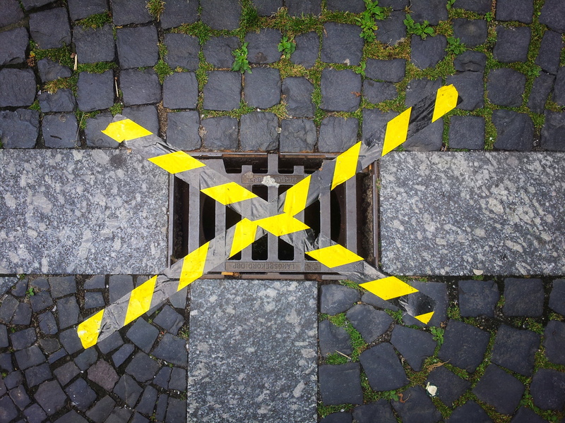 tape, flowering plant, flower, ground, road, stone, street, paving stone, day, footpath, gully, sign, asphalt, no people, high angle view, leaf, locked
