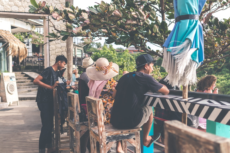 landmark, restaurant, promenade, women, outdoors, man, sitting, men, black, town, shorts, wooden, plant, resort, wear, group, tourism, stool, lifestyles