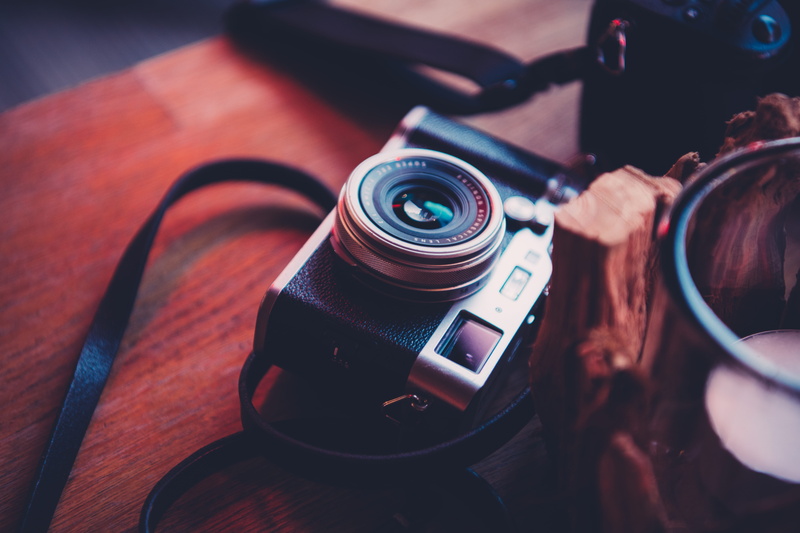 strap, table, face, photographic equipment, indoors, slr camera, photo, lens - optical instrument, reflection, close-up, film industry, wood - material