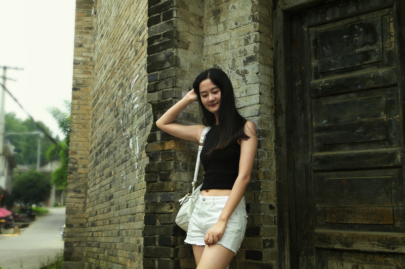colorful town, hair, built structure, color mixing, casual clothing, brick, fashion, hairstyle, one person, three quarter length, day, leisure activity