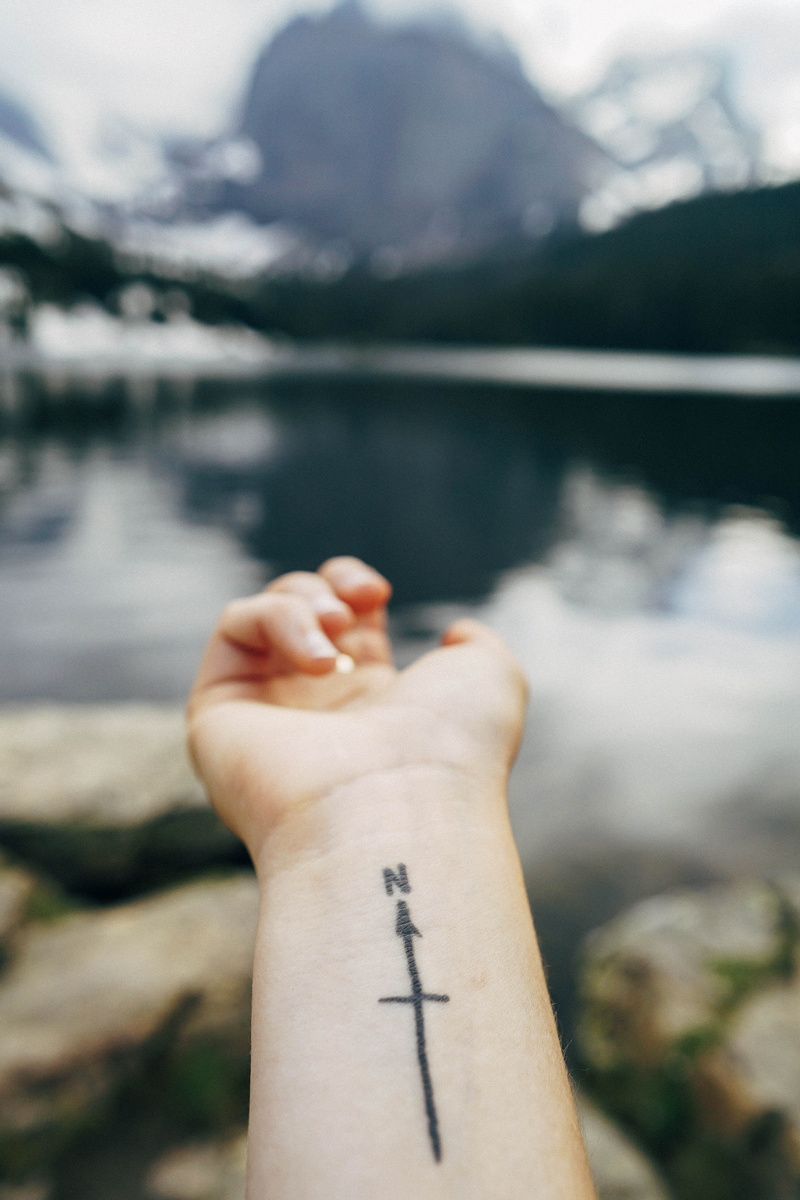 body part, lake, one person, tattoo, mountain, arm, north, person, travel, real people, tattooed, arrow, human body part, unrecognizable person, nature