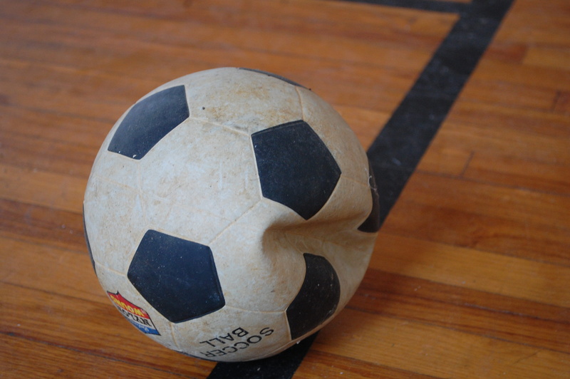 dirty, wood - material, day, shape, representation, game, indoors, still life, human representation, deflated, sports equipment, old, soccer ball, soccerball