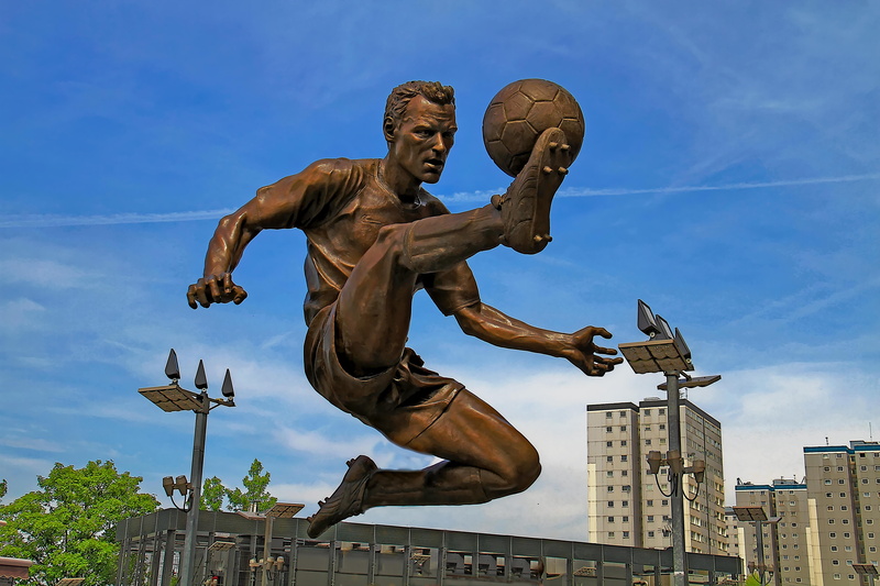 male likeness, kicker, man, 5K, sky, history, day, cloudy, soccerball, art and craft, creativity, architecture, blue, cloud - sky, soccer, nature, statue