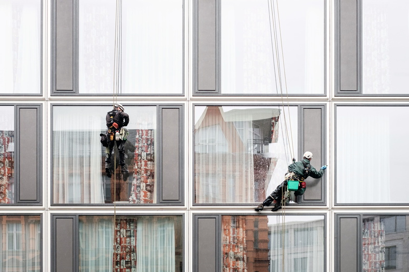 day, hat, window blind, two, window washer, outdoors, architecture, reflection, workwear, work, built structure, city, protective workwear, man, high, two people