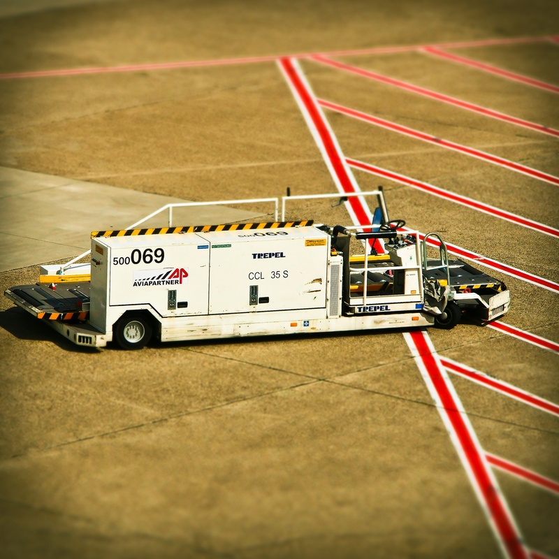 car, tilt shift, still life, high angle view, motor racing track, indoors, airport, miniature effect, sport, auto racing, prior to, accuracy, mark, selective focus