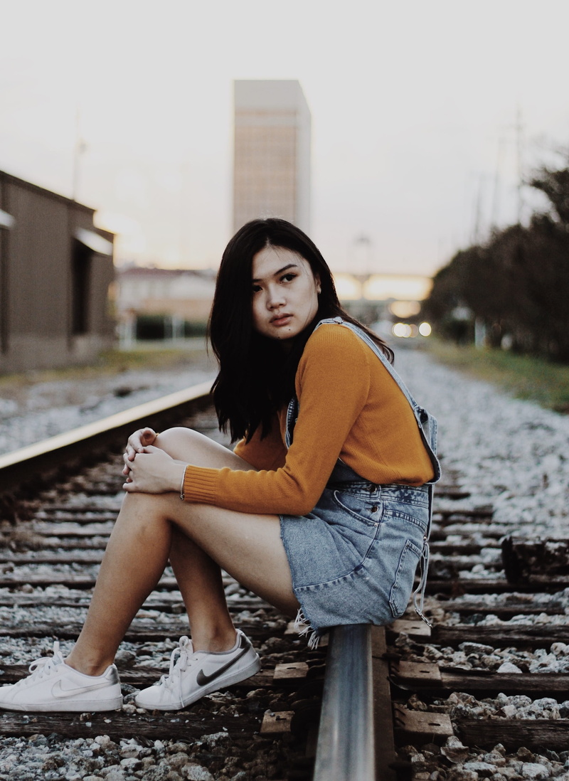 2K, portrait, contemplation, track, real people, day, train track, built structure, hairstyle, beautiful woman, railway, outdoors, footwear, adult, casual clothing