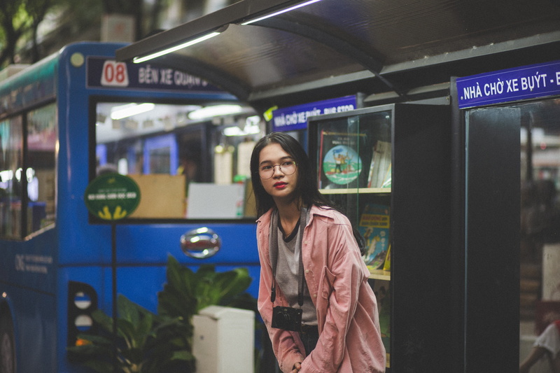 transportation, adult, arcade game machine, fashion, train, mode of transportation, coat, focus on foreground, shelf, rail transportation, shed, looking at camera