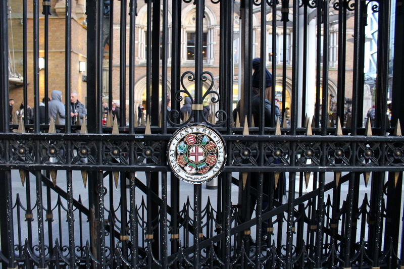 architecture, design, metal, wrought iron, sign, pattern, railing, emblem, iron gate, men, building, station, focus on foreground, building exterior, outdoors