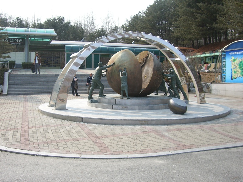 tree, built structure, lifestyles, city, statue, day, building exterior, sculpture, dmz, plant, war, outdoors, border, pushing, real people, memorial, park