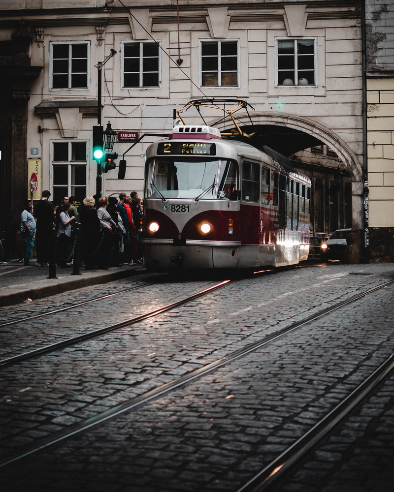 railroad track, group of people, architecture, travel, steeple, city, human, vehicle, railroad station, prague, public transportation, tram, street, outdoors