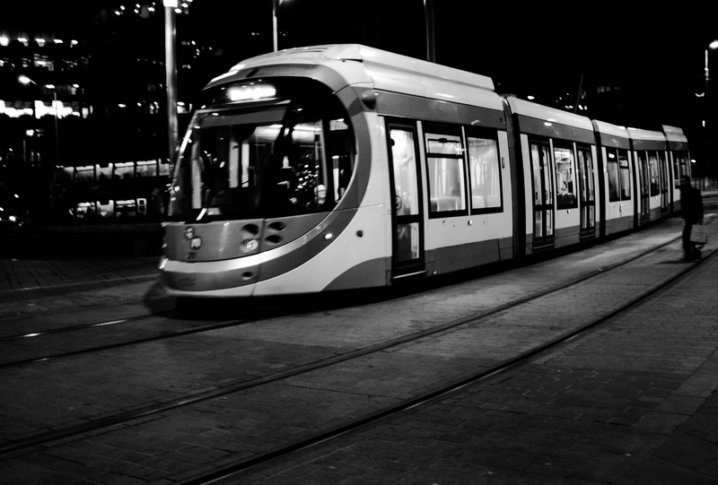 incidental people, blur, streetcar, railroad station, railroad track, trolley, street, united kingdom, human, building, built structure, illuminated, train