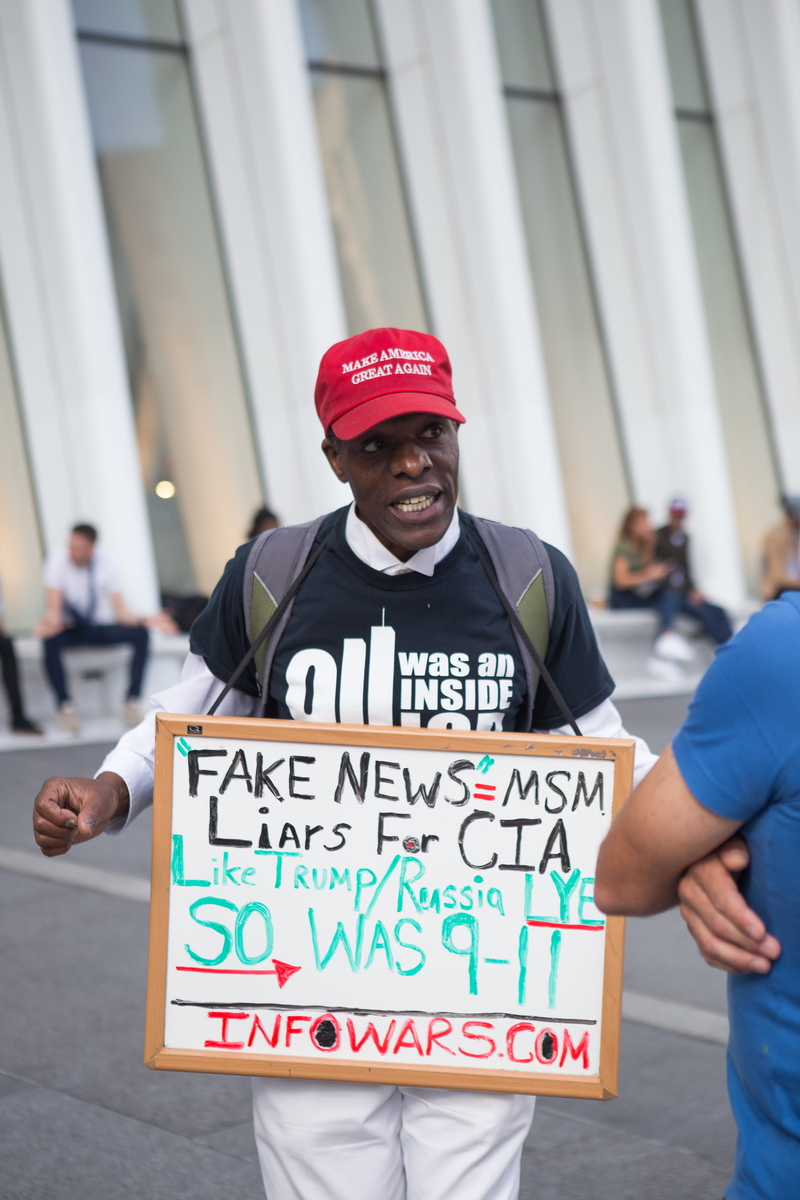 focus on foreground, looking at camera, new york city, msm, message, communication, happiness, walking, portrait, red, cap, cia, city, casual clothing