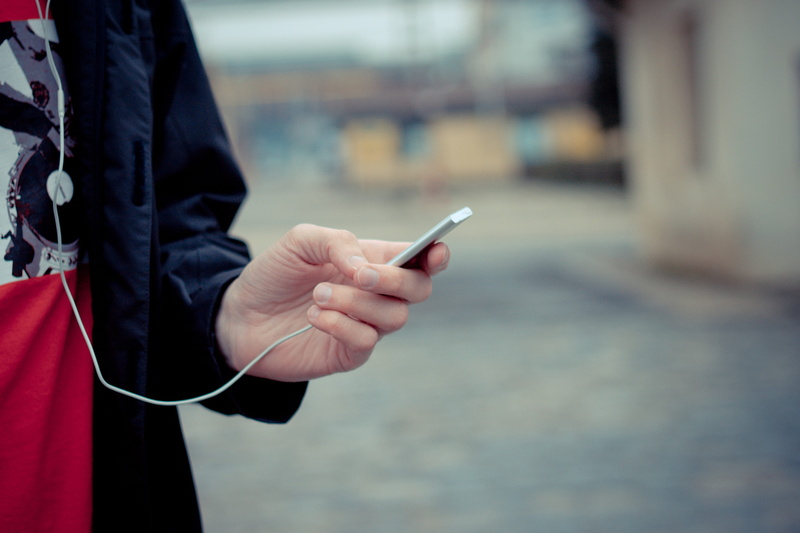 human hand, outdoors, portable information device, sound, technology, one person, selective, midsection, smart phone, real people, music, music playback
