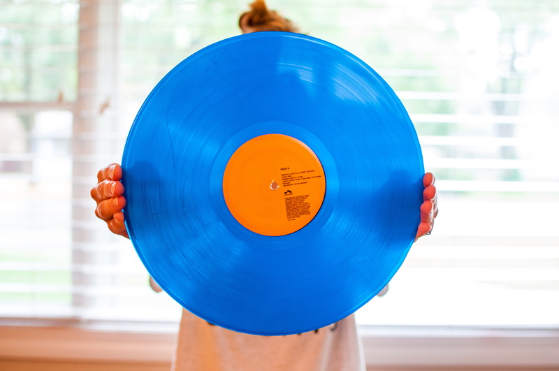 young adult, indoors, focus on foreground, one person, adult, healthy lifestyle, blue, lp, close-up, wax, record, front view, holding, 4K, orange, human body part