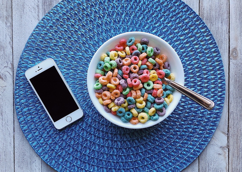connection, indoors, iphone, no people, bowl, rainbow colors, eating utensil, directly above, spoon, food, smart phone, fruit loops, technology, high angle view