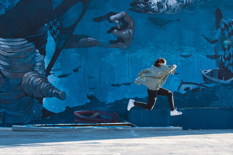 jumping, mid-air, black, wall, art, blue, near, graffiti, underwater, real people, full length, aquarium, animals in the wild, tank, one person, swimming