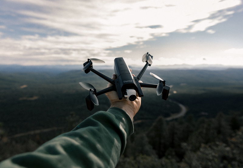 outdoors, holding, sweater, mountain Range, flying, scenics, mountain, sport, cloud - Sky, air Vehicle, cloud, adventure, drone, one Person, hand, landscape