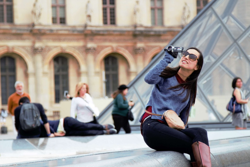city, glasses, tourist, front view, incidental people, sitting, outdoors, adult, woman, one person, young men, day, lifestyles, young adult, focus on foreground