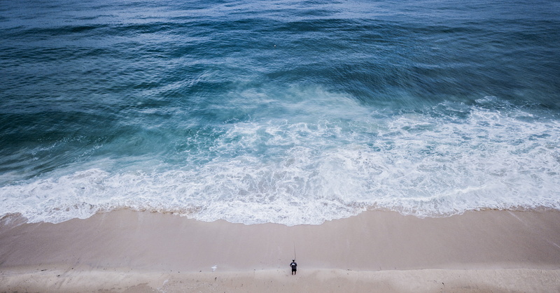 sea, blue water, seashore, ocean, beauty in nature, sand, drone view, outdoors, nature, front, land, aerial view, body, motion, person, high angle view