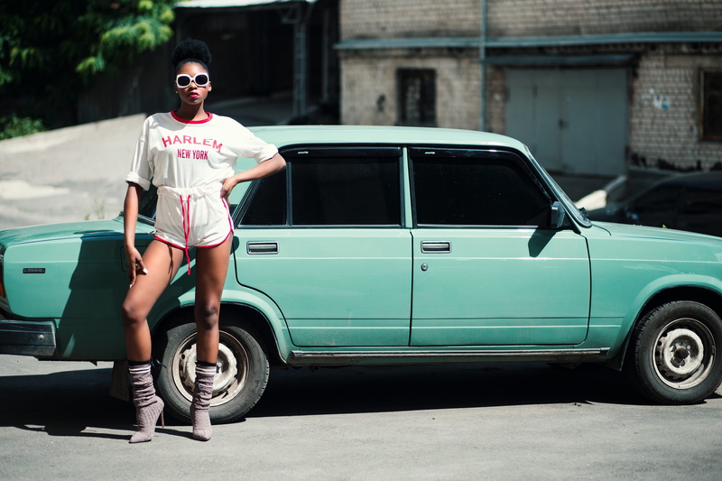 mode of transportation, vehicle, teal, looking at camera, day, sunglasses, person, legs, portrait, land vehicle, front, woman, glasses, wheels, real people