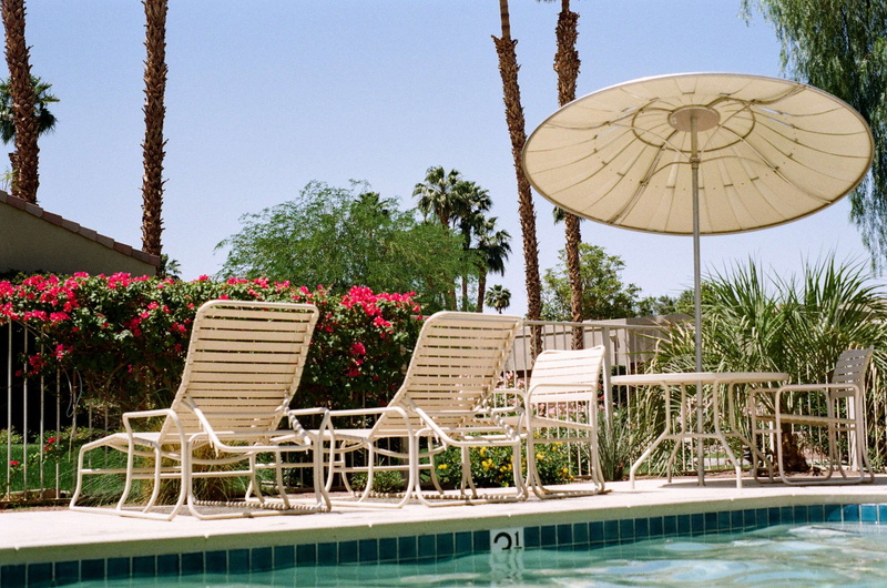 travel destinations, architecture, outdoor chair, tourist resort, outdoors, loungers, vacation, sky, sunlight, lounge chair, built structure, tree, poolside