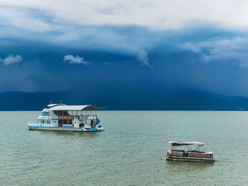 lake, nature, mode of transportation, stormy horizon, jocotepec, outdoors, dark sky, sailing, passenger craft, no people, ajijic, storm brewing, day, retirement town