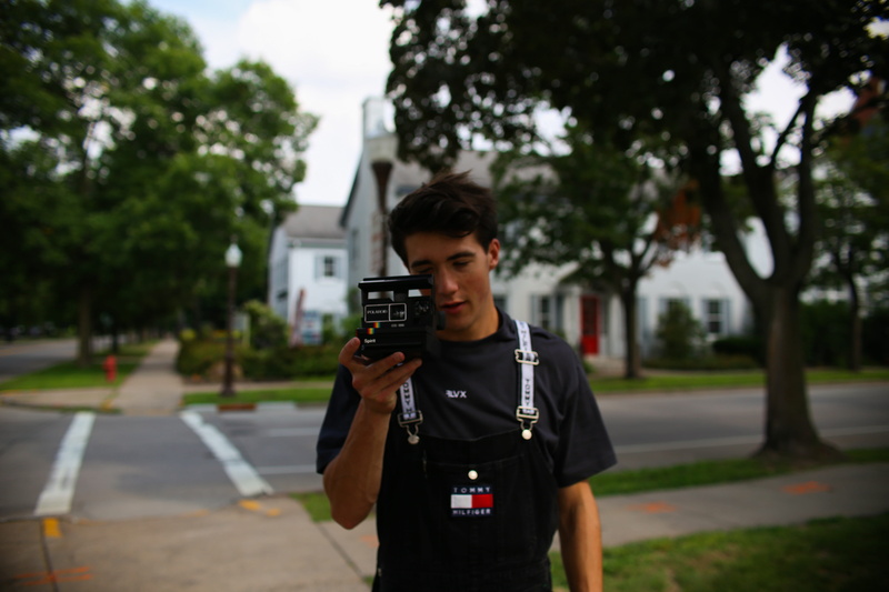photography, young adult, city, standing, tree, mans, black, waist up, 5K, outdoors, leisure activity, plant, camera, communication, polaroid, wireless technology