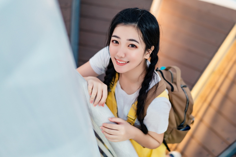 Asian, backpack, red lipstick, women, dark hair, painted nails, braided hair, braids, high angle, looking at viewer, 2K, backpacks, bokeh, indoors, overalls