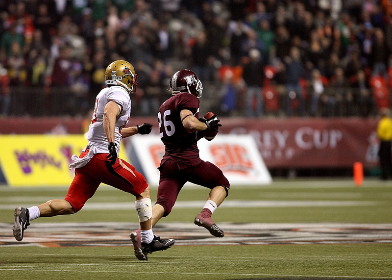 focus on foreground, people, players, defense, spectators, sports helmet, runner, championship, football, pigskin, headwear, sport, sports team, playing