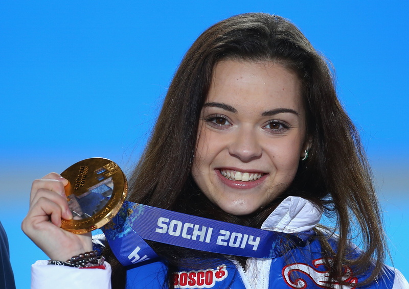 smiling, looking at camera, one Person, blue background, hairstyle, front view, women, holding, human face, cheerful, sochi 2014, headshot, outdoors, adelina sotnikova