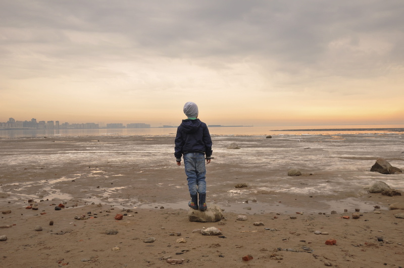 water, lifestyles, outdoors, warm clothing, full length, sky, coast, horizon over water, baby, scenics - nature, horizon, hood - clothing, real people