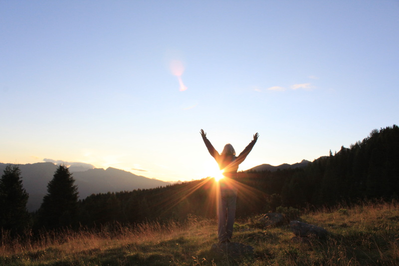ziano di fiemme, arms raised, outdoors, silhouette, tranquil scene, sun, one person, sunbeam, 5K, lens flare, sky, hand, leisure activity, mountain, tranquility