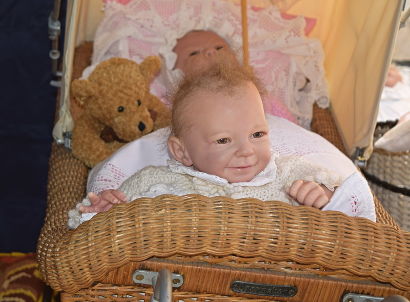 doll, old stroller, brown, one person, innocence, bassinet, wicker, looking at camera, baby, smiling, babyhood, sweet, toy, front view, young, container