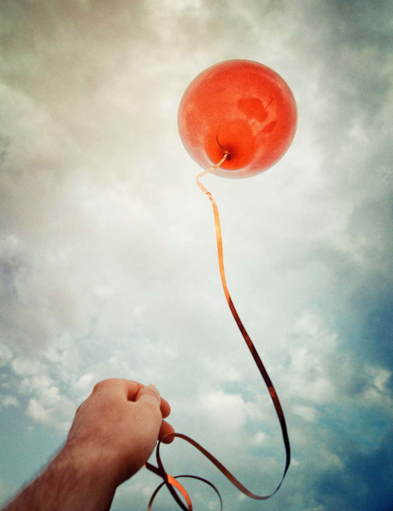 human finger, balloon, birthday, flight, body part, outdoors, flying balloon, fly, unrecognizable person, sky, decoration, cloud - sky, human limb, human hand