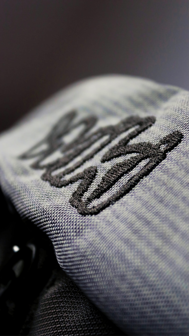 5K, casual clothing, full frame, brand, single object, clothing, close-up, focus on foreground, black, folded, textured, logo, wiki, warm clothing, selective focus