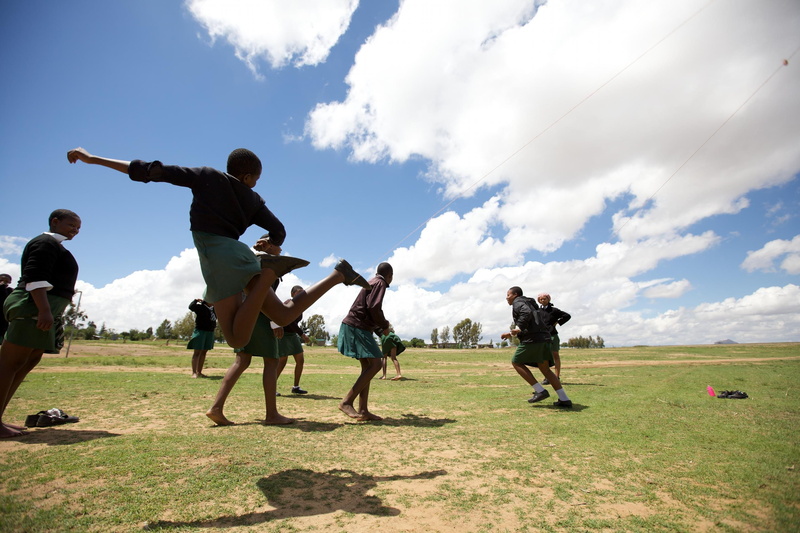 people, outside, outdoors, day, musical instrument, leisure activity, group of people, pre-adolescent child, field, trees, playing, adult, child, cloud - sky