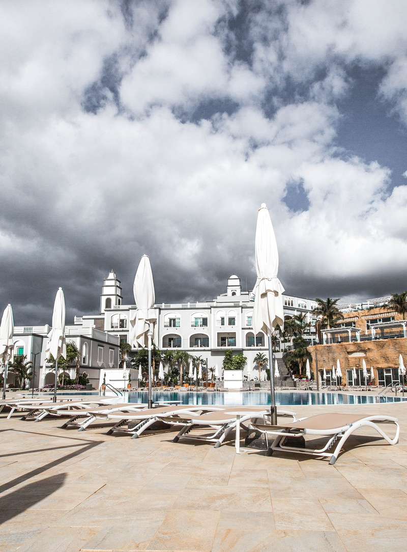 building, sky, exterior, cloud - sky, 4K, tourism, pool, holiday, poolside, city, hotel, outdoors, no people, history, spain, travel destinations, built structure