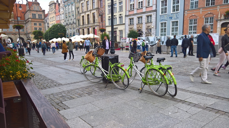 city life, building exterior, paving stone, transportation, bikes, crowd, architecture, built structure, adult, group of people, real people, city, day